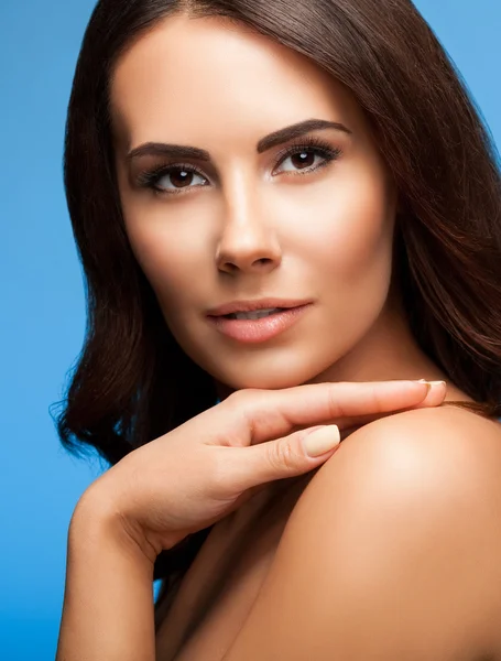 Portrait of beautiful young woman with naked shoulders, on blue — Stock Photo, Image