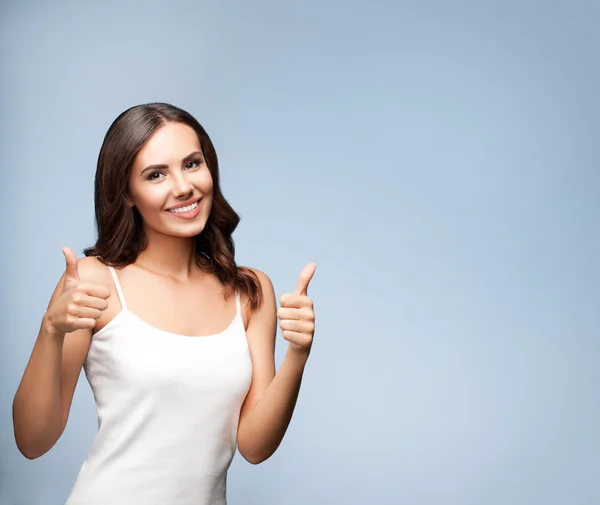 Портрет щасливої жінки, що показує великий палець жестом, на сірому — стокове фото