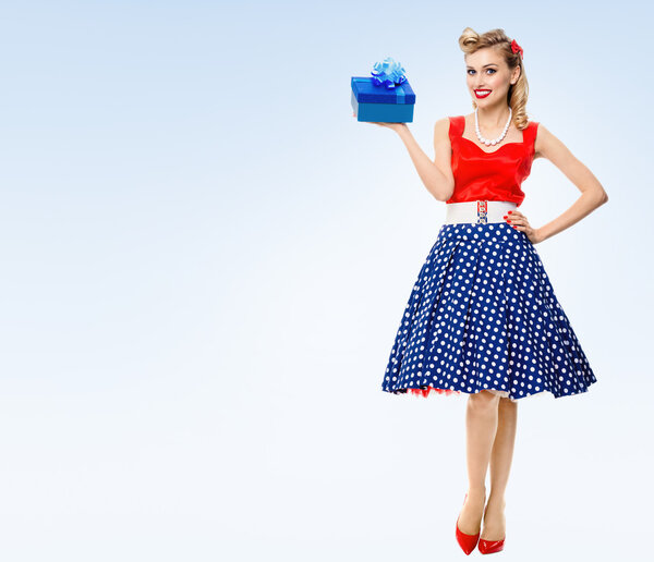 Full body of woman in pin-up style dress with gift box