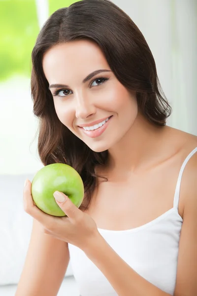 绿色的苹果，在室内的年轻快乐微笑女子 — 图库照片