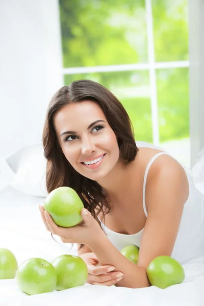 Feliz mujer sonriente con manzanas verdes, en el interior — Foto de Stock