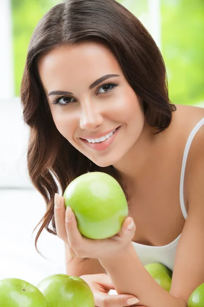 Unga leende kvinna med gröna äpplen — Stockfoto