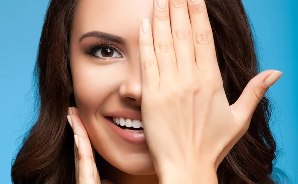 Donna con un occhio chiuso a mano, su blu — Foto Stock