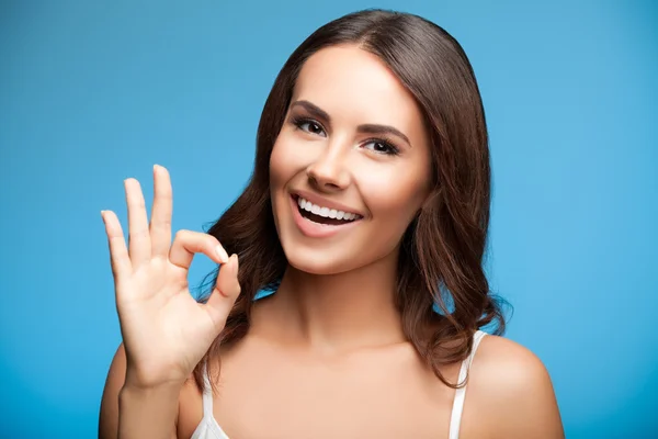 Kvinnan visar okej eller noll hand gest, på blå — Stockfoto