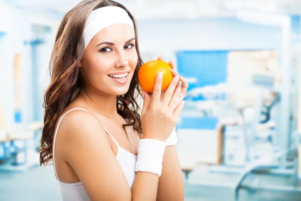 Frau mit Orange im Fitnessstudio — Stockfoto