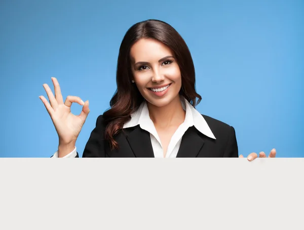 Empresária mostrando placa em branco no azul — Fotografia de Stock