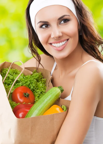 Mujer sonriente feliz en ropa de fitness con comida vegetariana —  Fotos de Stock