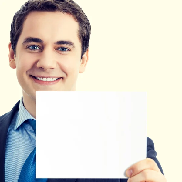 Empresário sorridente feliz mostrando placa em branco — Fotografia de Stock