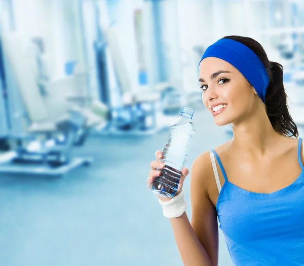 Woman in sportswear drinking water, at gym — Stock Photo, Image