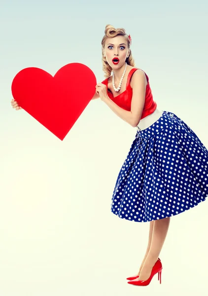 Mulher sorrindo segurando símbolo coração, vestido em estilo pin-up — Fotografia de Stock