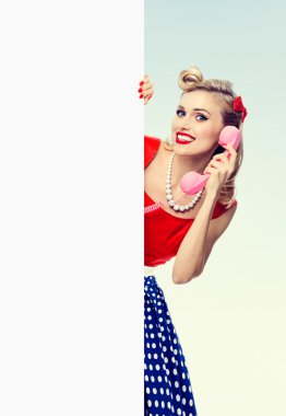 boş tabela gösterilen telefon, pin-up tarzı elbiseli kadınla