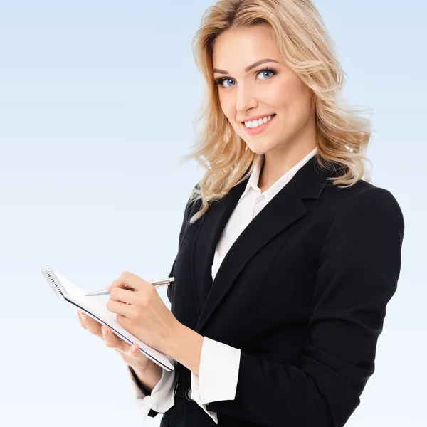 Businesswoman with clipboard writing — Stock Photo, Image