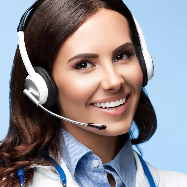 Feliz médico sonriente en auriculares, en azul —  Fotos de Stock