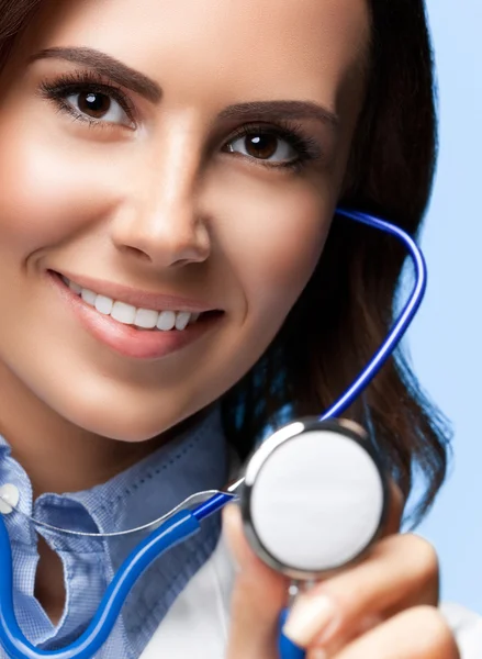 Doctor with stethoscope in hand, on blue — Stock Photo, Image