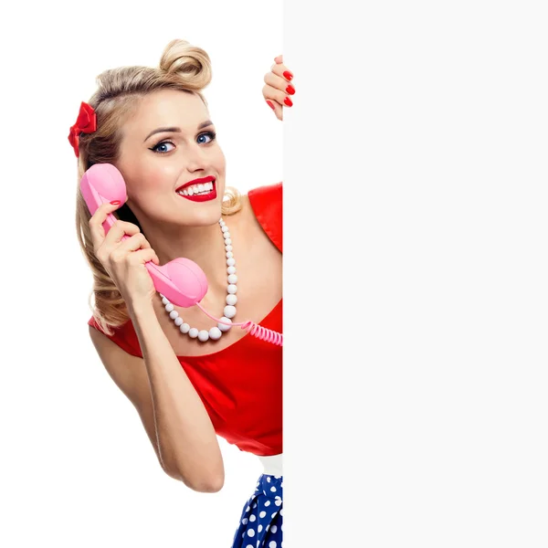 Γυναίκα με τηλέφωνο, σε στυλ pin-up-φόρεμα, δείχνει κενός πινακίδα — Φωτογραφία Αρχείου
