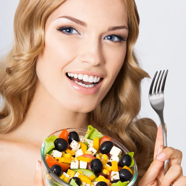 Femme avec salade végétarienne, sur gris — Photo