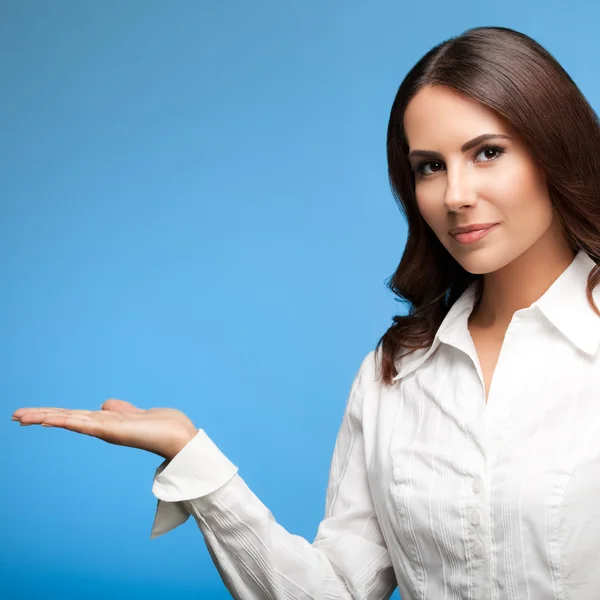 Affärskvinna visar eller ge något, på blå — Stockfoto