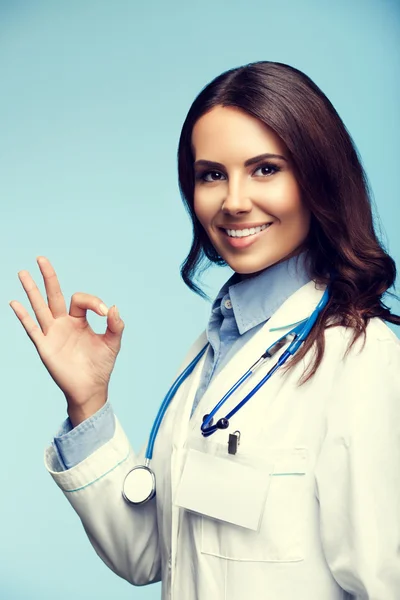 Jeune femme médecin montrant signe ok main, sur bleu — Photo