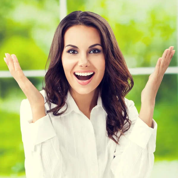 Erg blij gebaren lachende jonge brunette zakenvrouw met een — Stockfoto