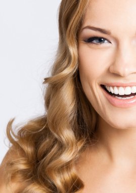 Genç neşeli gülümseyen kadın, gri 