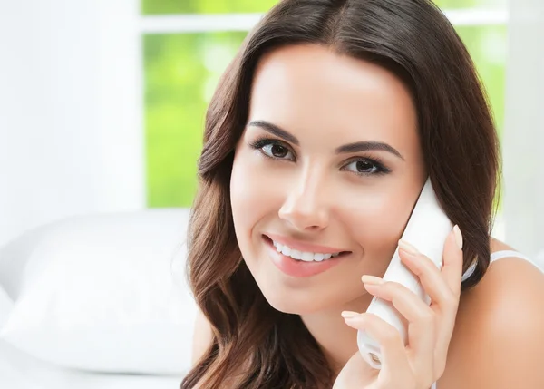 Jeune femme avec téléphone, à la maison — Photo