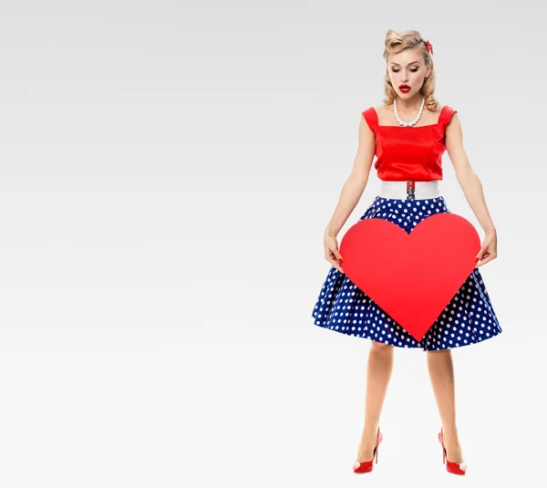 Smiling woman holding heart symbol, dressed in pin-up style — Stock Photo, Image