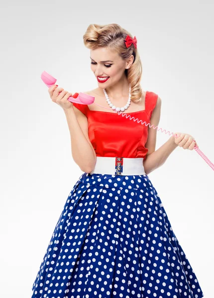 Smiling woman with phone, dressed in pin-up style dress — Stock Photo, Image
