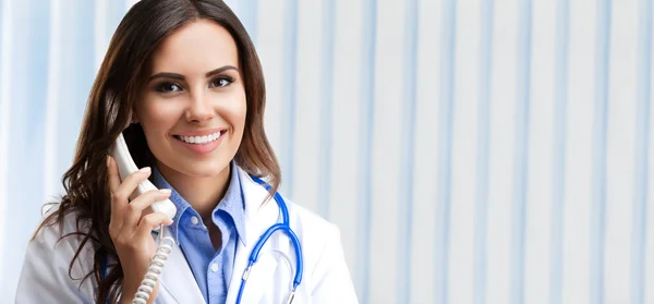 Lachende jonge dokter op telefoon — Stockfoto