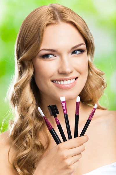 Lachende vrouw met make-up tools, buiten — Stockfoto