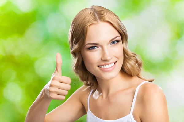 Happy woman with thumbs up gesture, outdoor — Stock Photo, Image