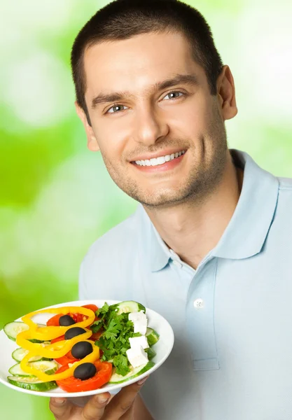 Buon uomo sorridente con piatto di insalata, all'aperto — Foto Stock