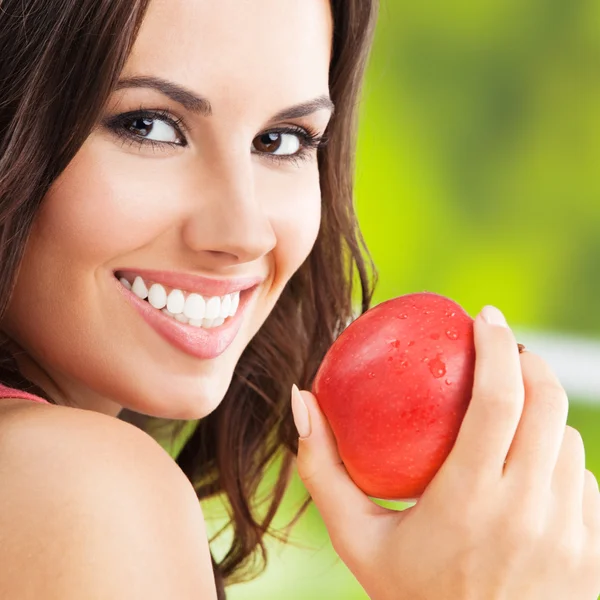 Mujer joven con manzana roja, al aire libre — Foto de Stock