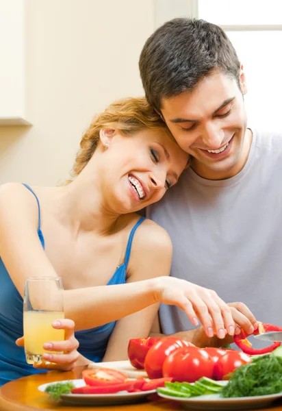 Cheerful young cooking couple at home — Stockfoto