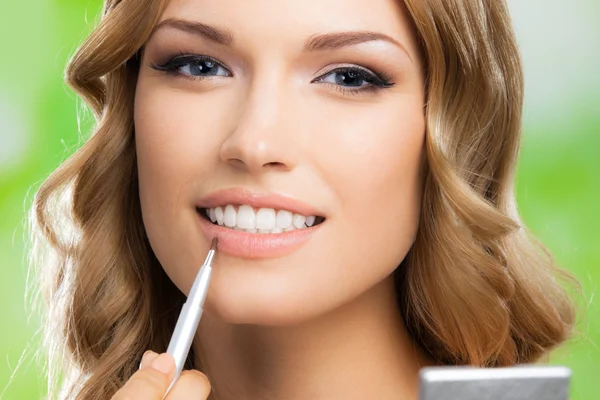 Mujer sonriente con cepillo de maquillaje, al aire libre —  Fotos de Stock