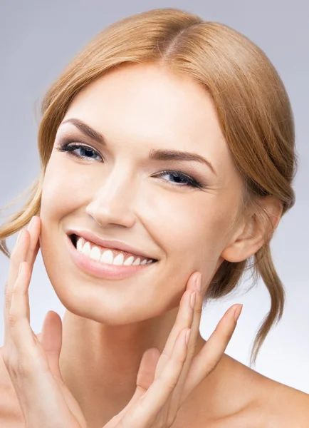 Woman touching skin or applying cream, on grey — Stock Photo, Image