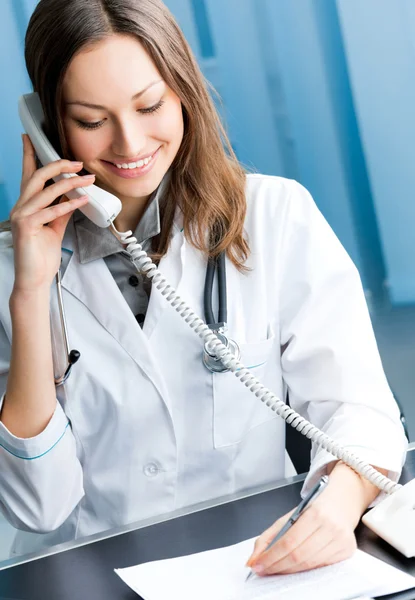 Jeune médecin au téléphone, au bureau — Photo