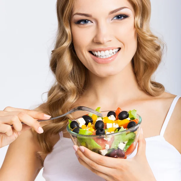 Mulher com salada vegetariana, sobre cinza — Fotografia de Stock