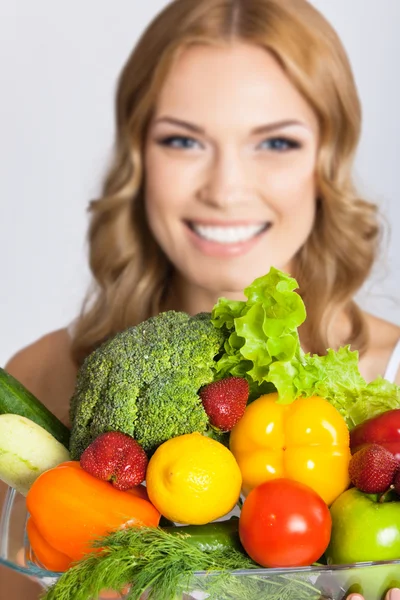 Mujer joven con comida vegetariana, sobre gris — Foto de Stock