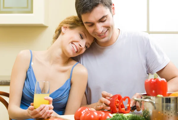Cheerful young cooking couple at home Stock Picture