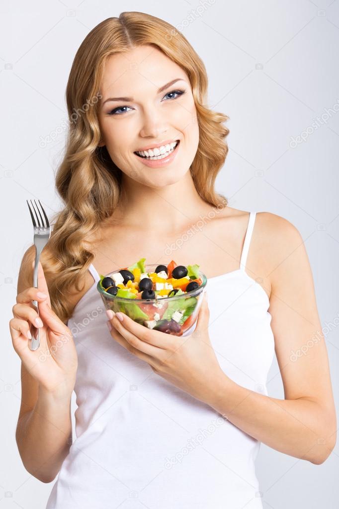 Woman with vegetarian salad, over gray