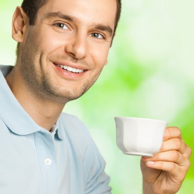 mutlu gülümseyen adam açık havada kahve içiyorsun