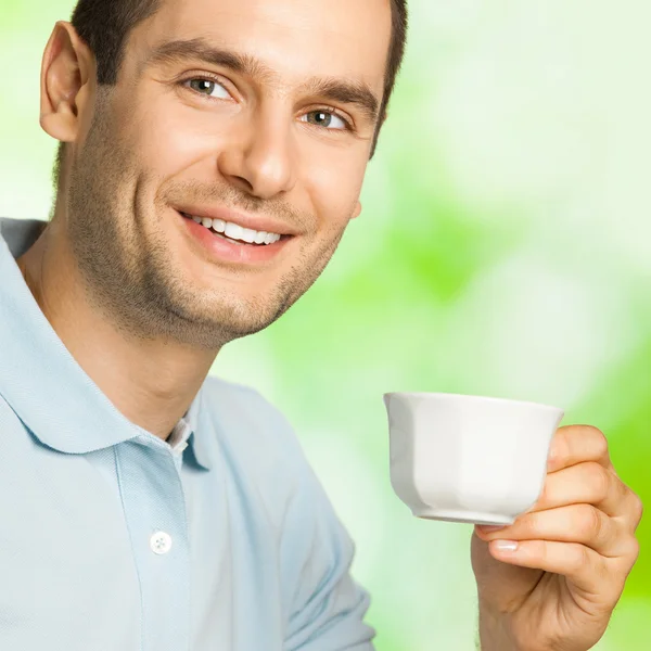 Heureux homme souriant boire du café, à l'extérieur — Photo