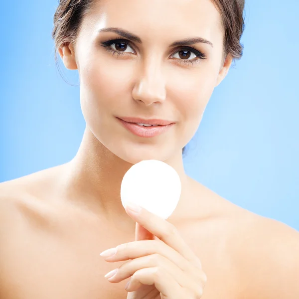 Young woman cleaning skin by cotton pad, over blue — Stock Photo, Image