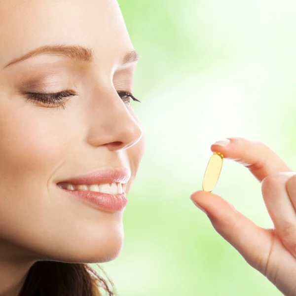 Woman with Omega 3 fish oil capsule, outdoor — Stock Photo, Image