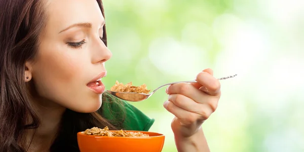 Женщина ест мюсли или кукурузные хлопья, на открытом воздухе — стоковое фото