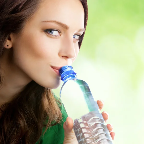 Женщина пьет воду из бутылки, на открытом воздухе — стоковое фото
