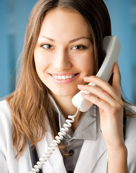 Jeune médecin au téléphone, au bureau — Photo