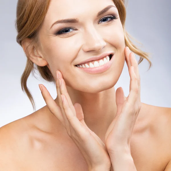 Woman touching skin or applying cream, on grey — Stock Photo, Image