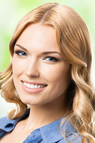 Bonne femme souriante aux cheveux longs, en plein air — Photo