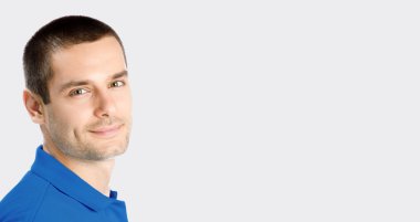 Gülümseyen genç çekici adam, gri karşı 